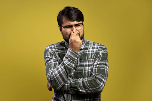 istock man with his hand on his nose, smelling a bad smell 1854874666