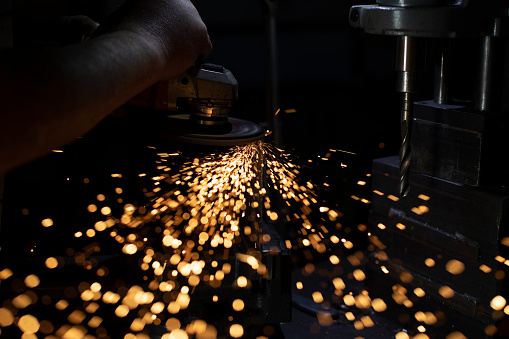 Sparks from grinding metal. Bright lights in dark. Cutting steel. Metal profile processing. Bright sparks from high temperature.