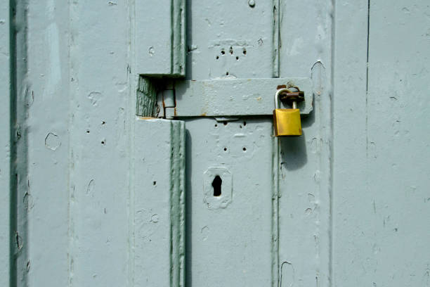 istock Padlock on gray wooden gate forming a textured background. 1854913537