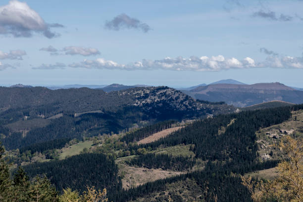 istock a picturesque landscape with verdant forests on rolling hills under a partly cloudy sky 1854915184