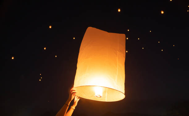 istock Thai people release sky floating lanterns or lamp to worship Buddha's relics at night. Traditional festival in Chiang mai, Thailand. Loy krathong 1854921571