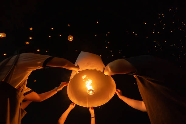 istock Thai people release sky floating lanterns or lamp to worship Buddha's relics at night. Traditional festival in Chiang mai, Thailand. Loy krathong 1854925745
