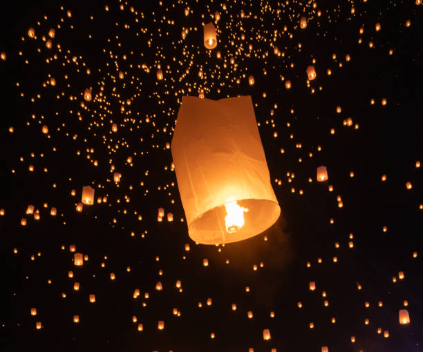 istock Thai people release sky floating lanterns or lamp to worship Buddha's relics at night. Traditional festival in Chiang mai, Thailand. Loy krathong 1854926319