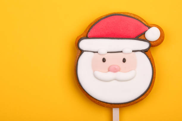 istock Santa Claus Gingerbread Cookie Pop on yellow background 1854928515