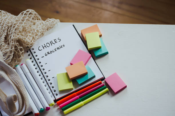 istock High angle view of notebook with multi colored sticky notes on white table for organizing and productivity 1854943917