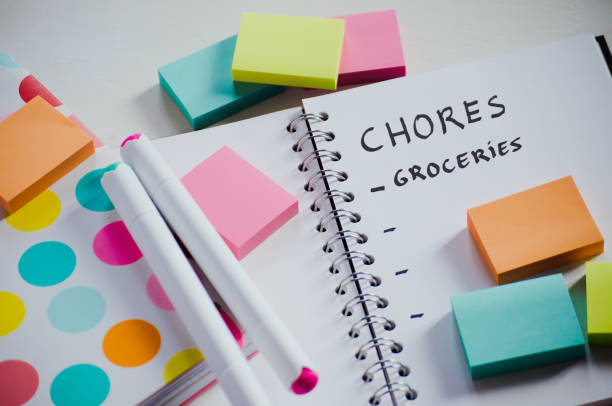 istock Directly above shot of notebook with multi colored sticky notes on white table for organizing and productivity 1854944460