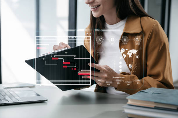istock Woman hand Project manager working and update tasks and Gantt chart scheduling virtual diagram.with smart phone, tablet and laptop in office. 1854948842