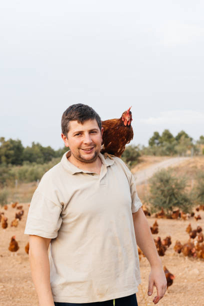 istock Friendly man with chicken on farmyard 1854952561