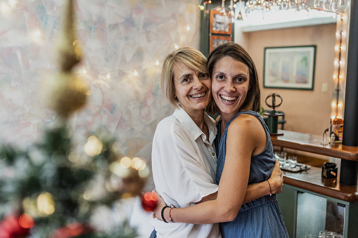 Portrait of mother and daugher embracing on christmas at home
