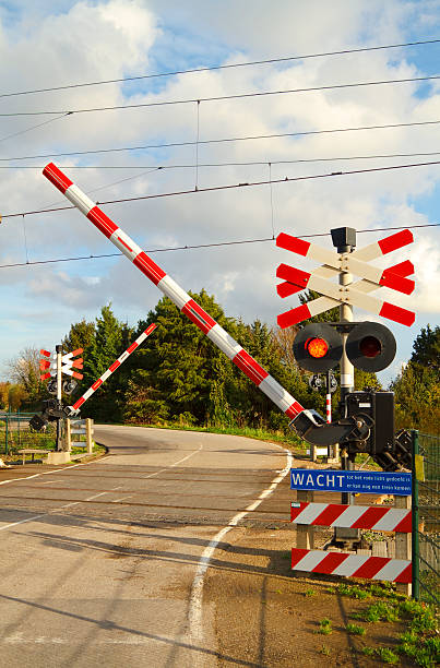 passagem de nível em uma estrada sinuosa - railroad crossing railway signal gate nobody imagens e fotografias de stock
