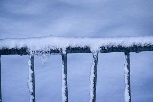 An abstract image or background of a metal gate covered in snow
