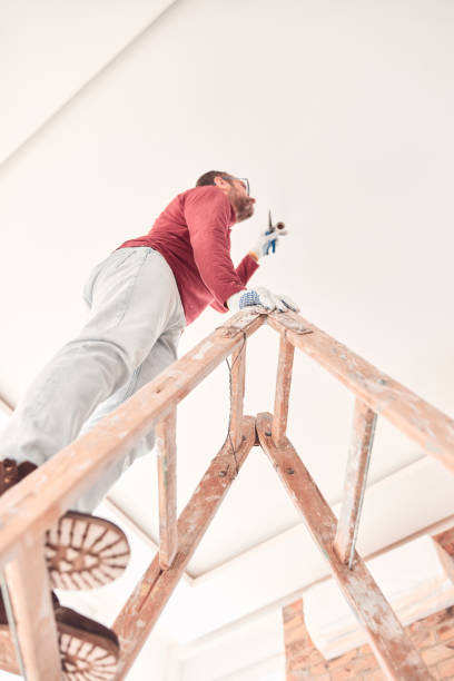 istock Handyman electrician with ladders working in a new home interior. 1855015325