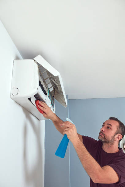 istock Man cleaning and maintaining air condition unit. 1855016983