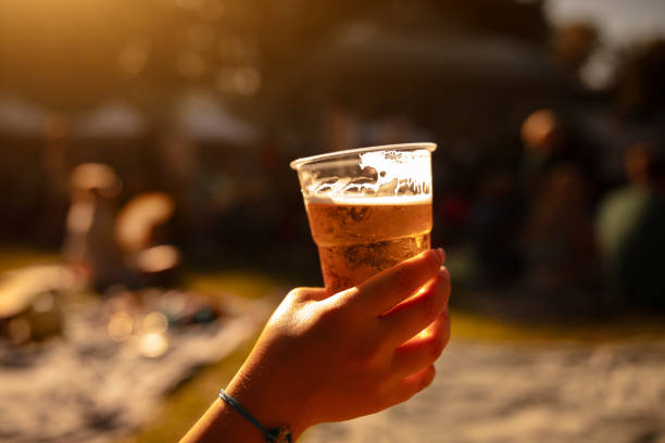 istock Person holding beer cup outdoors on a sunny day. 1855027210