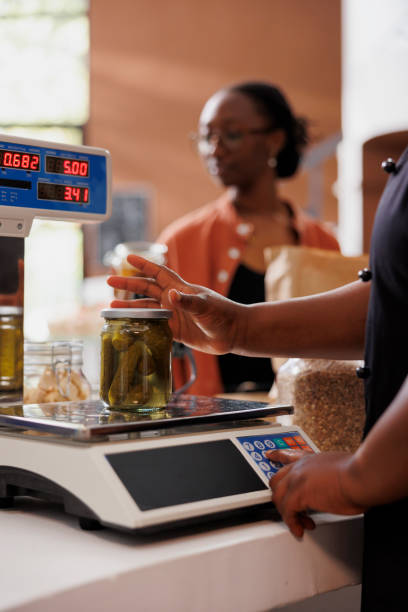 istock Vendor weighing fresh jar of pickles 1855043106