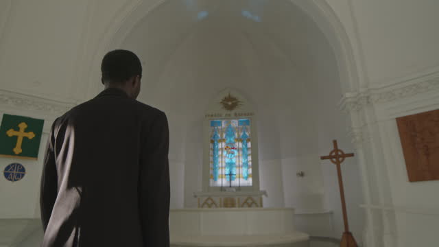 Back View of Priest Walking in Church