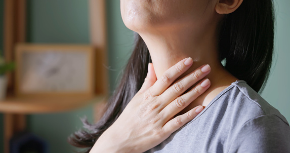 close up of asian woman with thyroid gland problem - she suffering from sore throat