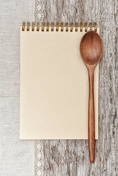 weißbuch notebook, kochlöffel und stoff auf dem alten holz - domestic kitchen pattern old scratched stock-fotos und bilder