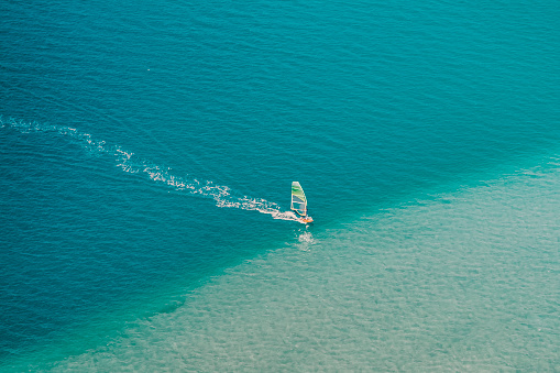 Jandia, Spain - June 17, 2022: The Sotavento it's a beautiful beach on the island of Fuerteventura, with clear sand and shallow turquoise waters. The strong wind makes it the ideal setting for windsurfing.