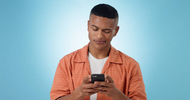 istock Doubt, confused and man with a smartphone, typing and connection on a blue background. Person, guy and model with a cellphone, mobile user and reaction with error 404, phishing and contact with app 1855093451