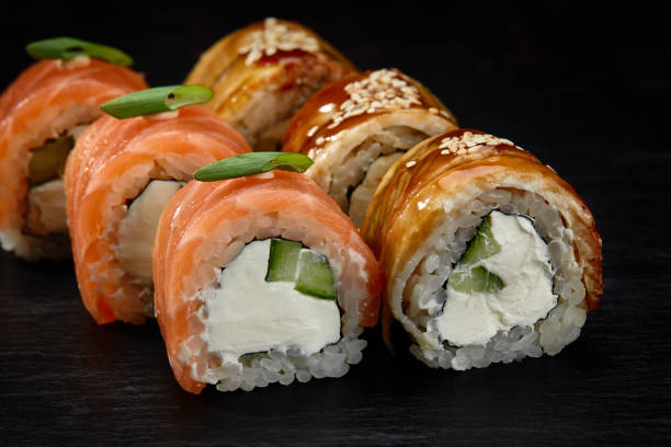 istock Traditional Japanese rolls with salmon and smoked eel in set on black background. 1855097814