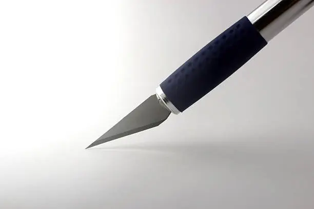 isolated sharp razorblade cutting sheet of blank paper