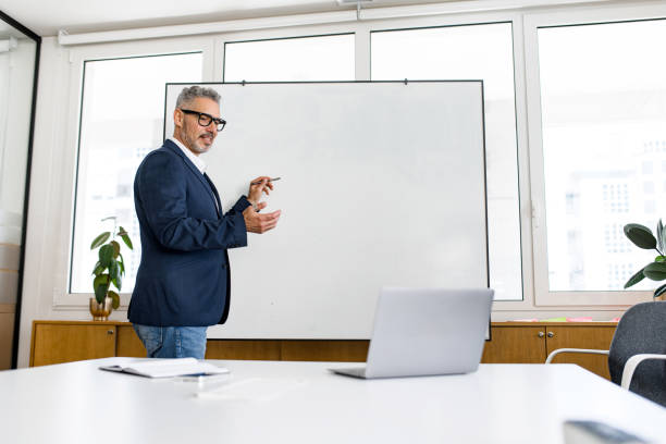 istock Mature male employee standing with whiteboard 1855113787