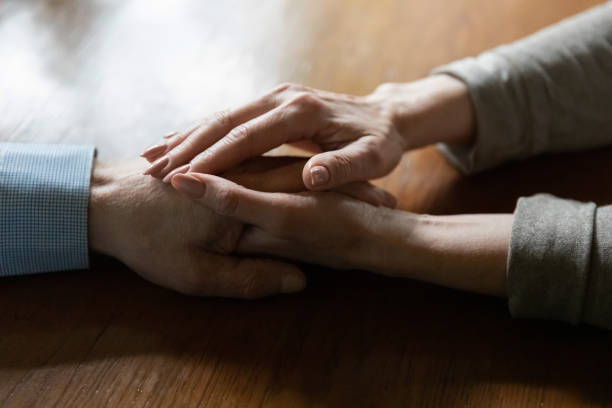 istock Affectionate middle aged woman touching mature man hand share hope 1855116521