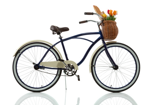 Beach cruiser with basket that has tulips and bread in it isolated on white side view