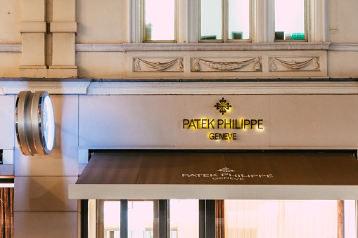 London, UK - 11 December, 2023: exterior architecture and storefront of the Patek Philippe store in New Bond Street in central London, UK. The store is illuminated at night.