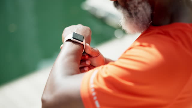 Runner, smart watch or hands of man on break in running training, workout or outdoor exercise. Retirement, senior or healthy athlete in city with tech to monitor heartbeat or wellness for fitness