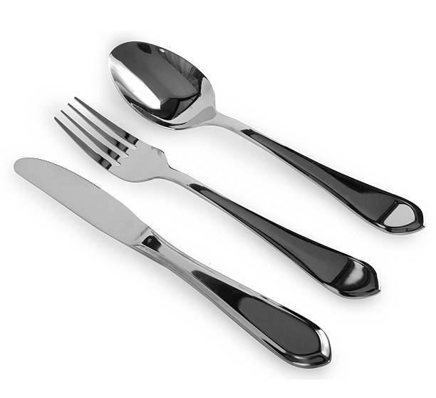 Metal spoon and two forks formed into conceptual fantasy figure. Spoon and forks sitting at the table.