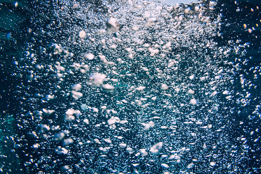 Blue ocean and a lot of air bubbles in transparent water.