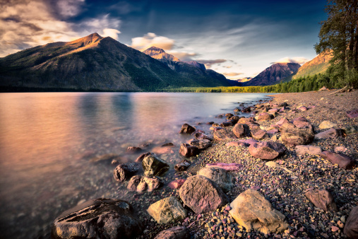 Serene Lake McDonald in Glacier National Park, MT surrounded by mountains and a pine forest