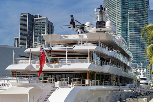 Miami, Florida, USA - 5 December 2023: Rear view of the luxury super yacht Infinity in Miami with a helicopter on the top deck. The ship is owned by Eric Smidt and was built by Oceanco in The Netherlands.