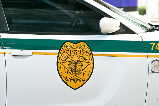 Miami, Florida, USA - 3 December 2023: Close up view of the badge on the side of a police patrol car operated by the Miami Dade police department