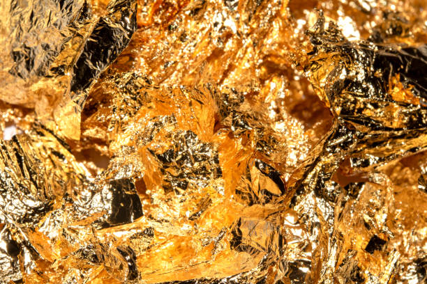 istock Gold Leaf Pieces Close Up on A White Background as Decorative Pieces 1855181919