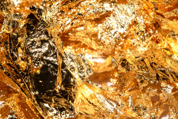 istock Gold Leaf Pieces Close Up on A White Background as Decorative Pieces 1855182425