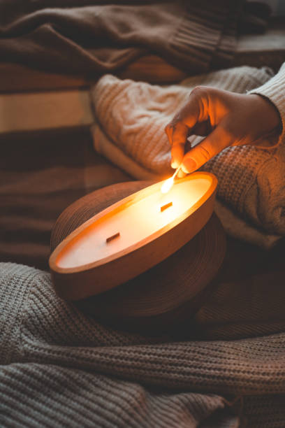 istock A match lights a candle in wood, stylish interior 1855196692