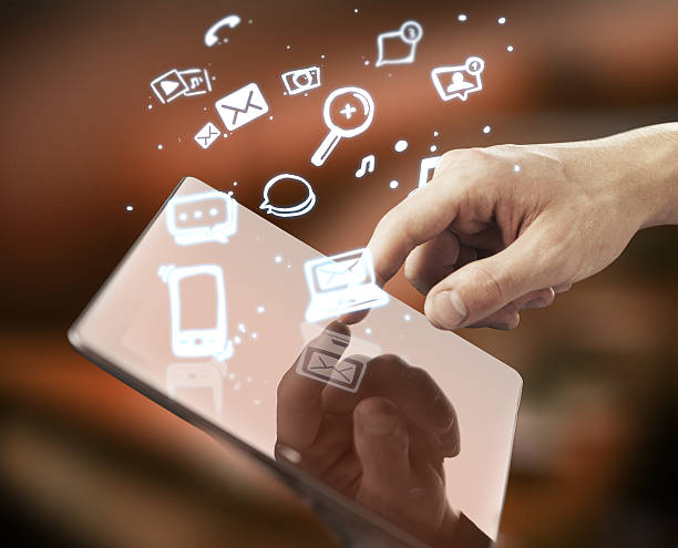istock Finger pushing on a tablet with icons flying out 185524166
