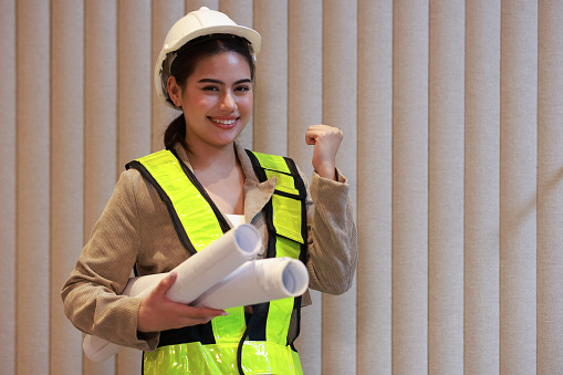 Business woman with green safety vest and white hard hat , engineering and business concept