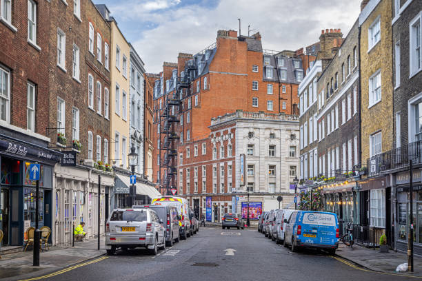 Tavistock Street, London, England - October 30th 2023:  View down a London street with architecture from different periods and in different heights and parked cars