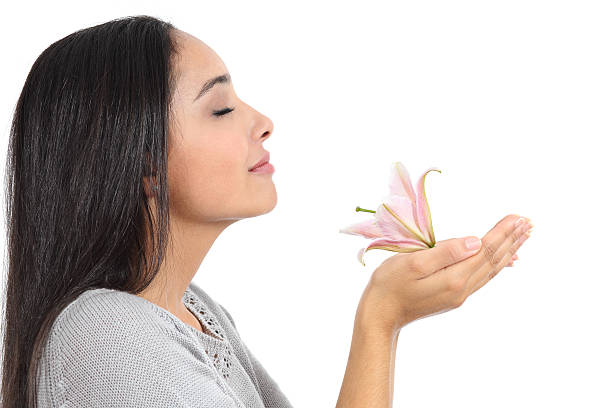 vista laterale di una donna di annusare un fiore arab - profumato foto e immagini stock