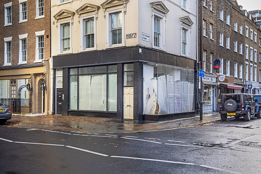 Tottenham Street, London, England - October 29th 2023: Bankrupt shop with paper in the windows at a street corner in the center of London