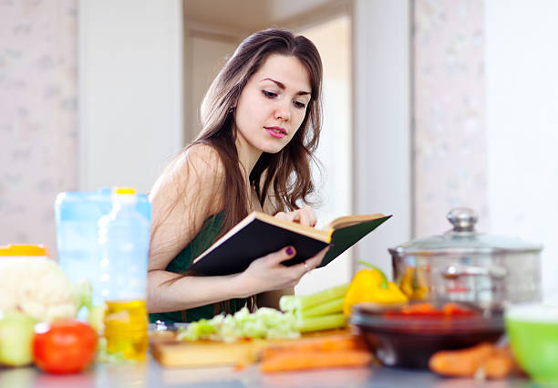istock beautiful housewife cooking with cookbook 185526865