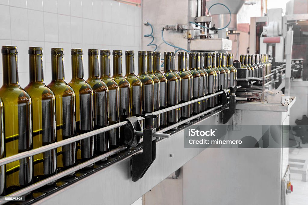 Automatic wine bottling process wine bottles filled with wine by an industrial machine in a wine factory Wine Stock Photo