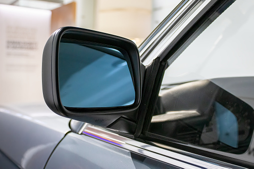 Close-up of a metal mirror of a modern car. Automotive transport or automobile industry concepts. View with copy space.