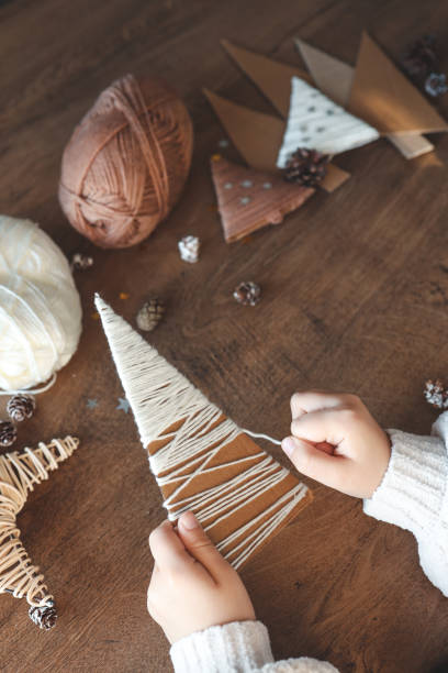 istock Child makes Christmas decoration from yarn 1855311238