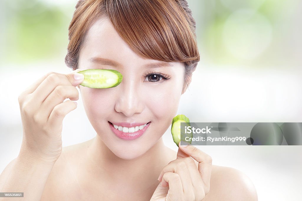 Linda mulher segurando fatias de pepino na frente - Foto de stock de Adulto royalty-free