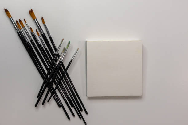 istock Group of black handle watercolor brushes next to blank sketchbook 1855364839